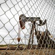 An oil pump behind a fence.