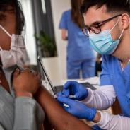 Nurse administering covid vaccine to a woman