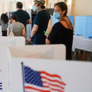Woman with mask waiting in line to vote in a U.S. election.