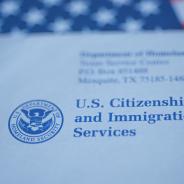 An envelope from the U.S. Citizenship and Immigration Services rests on the U.S. flag.