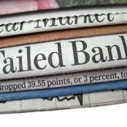 A stack of newspapers, one that reads "Failed Bank" in large print.