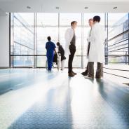 Doctors converse in a corridor.