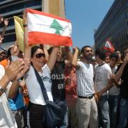 A protester holds up the Lebanese flag amongst other protesters.