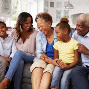 An African American family laughs together.