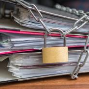 A lock and chains tie three binders together.