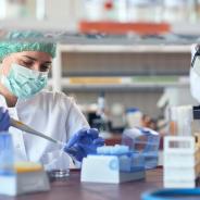 A scientist prepares a pipette in a lab.
