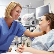 A nurse and a patient smile at each other.