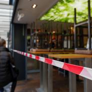 People walk past a closed business.
