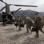 Military troops carry supplies to a helicopter in Afghanistan.