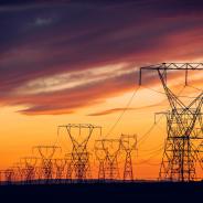 Power lines and transmission towers against a sunset.