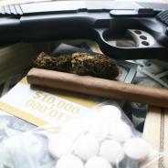 Drugs and a gun with money in a pile