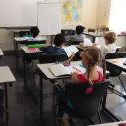 Children sit at desks in school