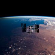The International Space Station (ISS) orbits the Earth at sunrise