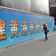 Person walks alongside large banner with Chinese characters