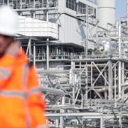 Inspector with refinery facility in background
