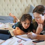 A mother teaches her daughter at home.