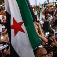 A young girl raises the Syrian opposition flag