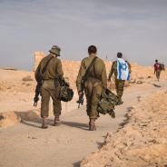 Several soldiers of Israel army walking with Israel national flag