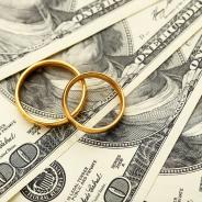  Golden wedding rings on one hundred dollars bill background 