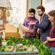 Landscape designers having discussion about city layout model 