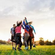 Group of active people jumping after doing exercise in nature. 