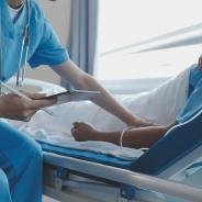 Physician holds patient's hand while encouraging and providing medical advice.