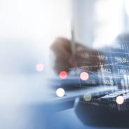 financial information superimposed over hands above keyboard