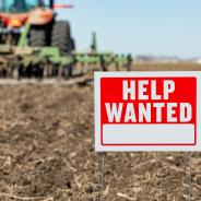 "Help wanted" sign superimposed on plowed land