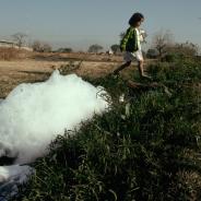 A girl walks by a polluted stream in Cuenavaca.