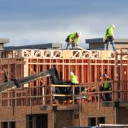  A crew of construction workers atop wooden structures, building a multistory apartment complex in East Mesa, Arizona.