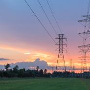Group silhouette of transmission towers at dusk