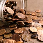 Glass jar with coins on table