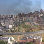 Israel and Palestine divided by wall with smoke and fire pisgat zeev and anata refugees camp, Jerusalem Israel-Aerial view