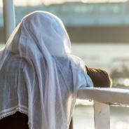  Licensed Find Similar File #:  94934002 Muslim woman on the fence of a boat overlooking the sea at sunset