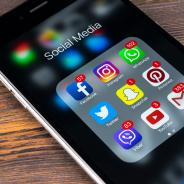 Apple iPhone 7 on wooden table with icons of social media