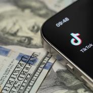 TikTok app on smartphone screen with dollar background