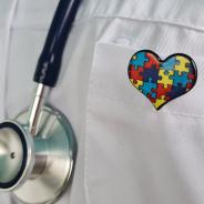 A Doctor Wearing a Stethoscope and a Puzzle Piece Heart Pin.