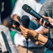 Reporters hold up microphones