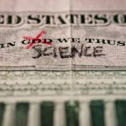 Word God crossed out and replaced by science on a US dollar bill. 