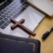  Cross on bible with headset and laptop in online study bible concept.