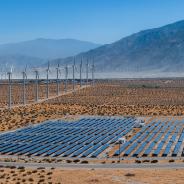 solar panels and wind turbines in desert landscape