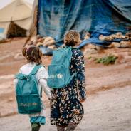 Refugee girls wearing UNICEF backpacks