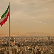 Iran Flag in the Wind Above Skyline of Tehran 