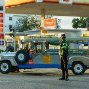 Traffic officer manages jeepney at petrol station