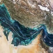 Satellite view of the Persian Gulf and Strait of Hormuz with glowing blue lines symbolizing naval traffic and strategic maritime routes amidst geopolitical tensions and regional conflict in Iran.