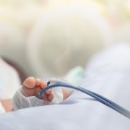Infant or newborn baby feet with pulse oximeter for determine oxygen saturation in baby's blood, in incubator at intensive room care in the hospital after delivery.