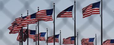 U.S. flags behind a chain-link fence