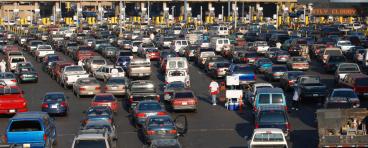 Multiple rows of cars lined up at the US-Mexico border. 