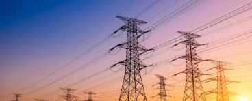 Transmission towers against a sunset.