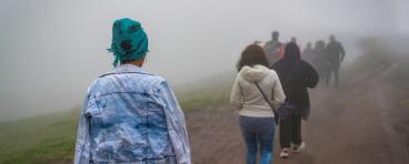 Refugees walk on dirt path